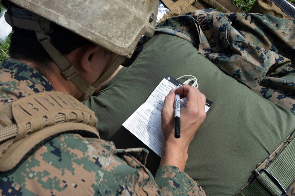 Two bloggers reviewing boat insurance documents on a dock with boats in the background