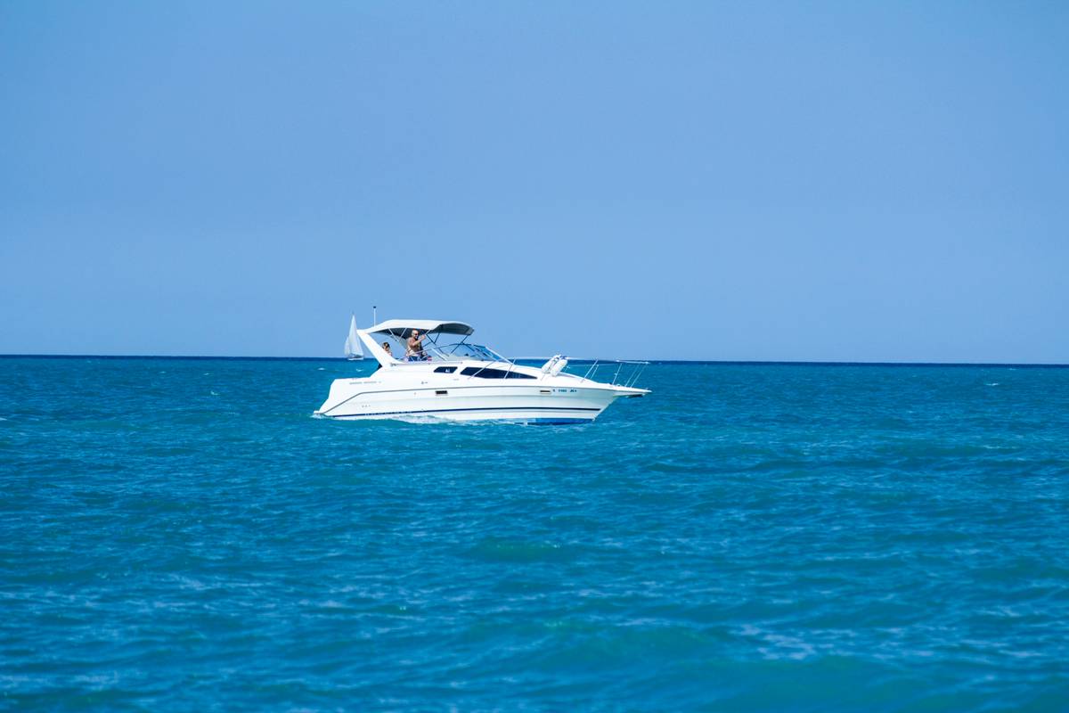 travel insurance boat rental showing a couple reviewing policy documents while standing next to a docked speedboat