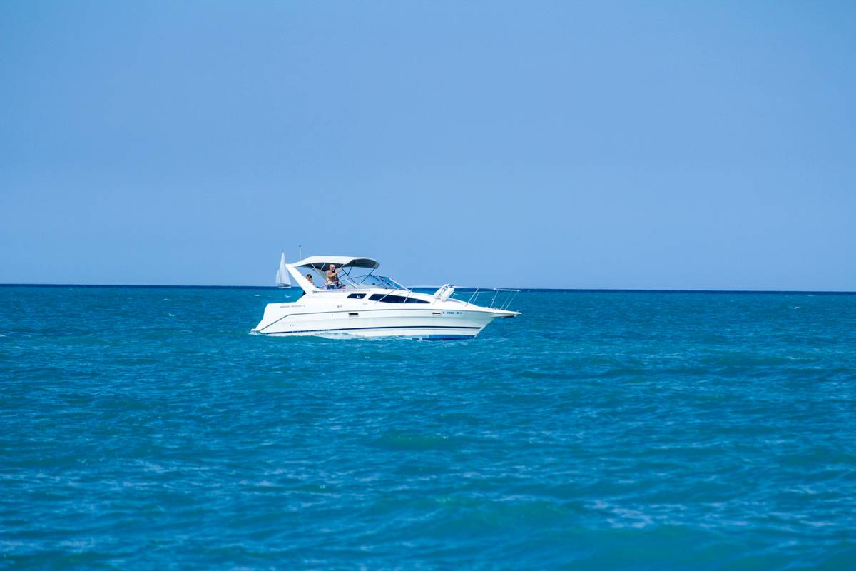 A couple reviewing boat rental paperwork while asking 'does travelers offer boat insurance' near a marina dock